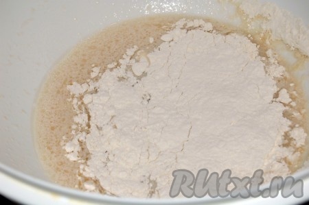 Муку просеять. Муку добавлять в миску постепенно, перемешивая тесто вначале ложкой, а затем продолжать замес руками. Следите, чтобы не добавить лишнюю муку, иначе дрожжевое тесто будет грубым. Муки нужно столько, чтобы тесто перестало липнуть к рукам.